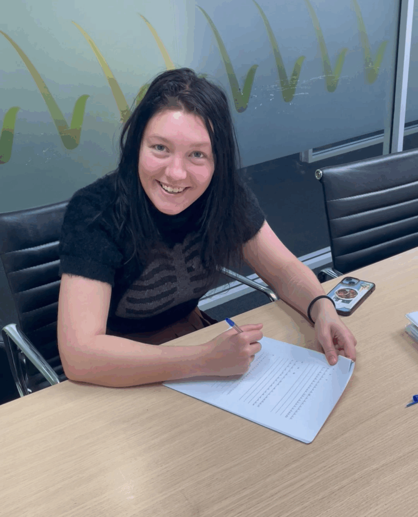 Zero sitting at a desk signing a document