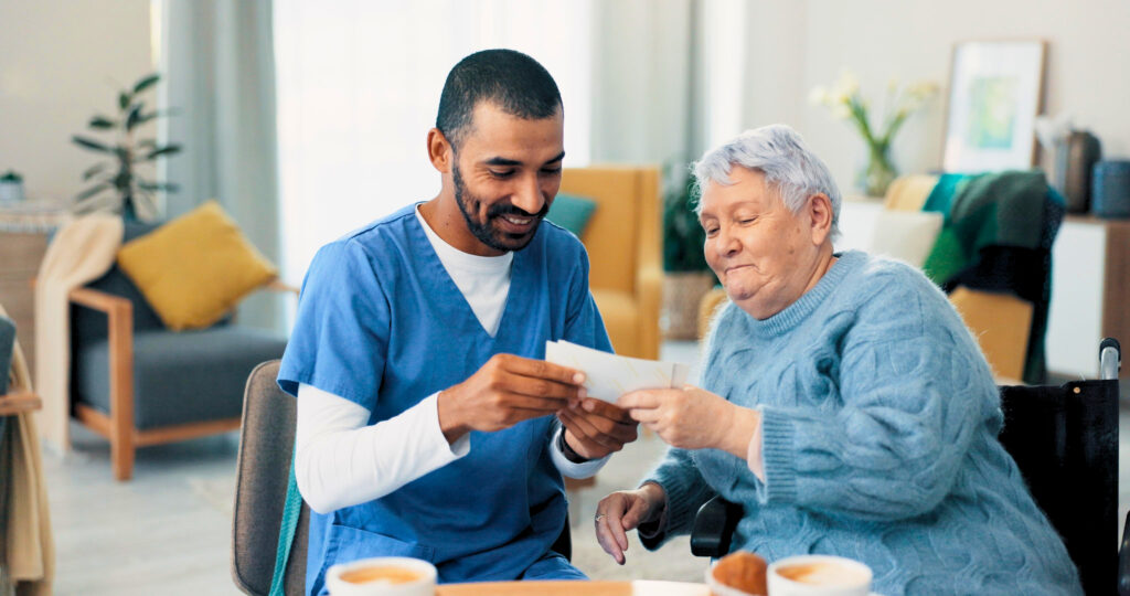 Elderly, photo album or caregiver with old woman in retirement talking or bonding together in nursing home. Love, memory or senior women with pictures for support or care with a happy nurse on break